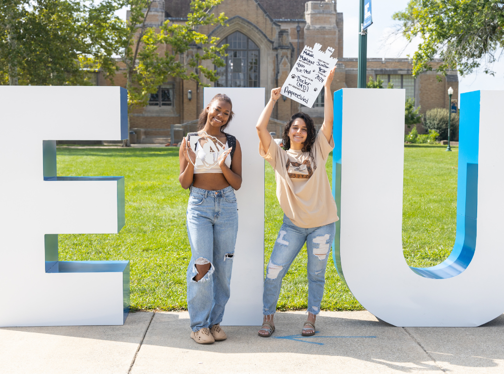 Students standing in front of EIU letters