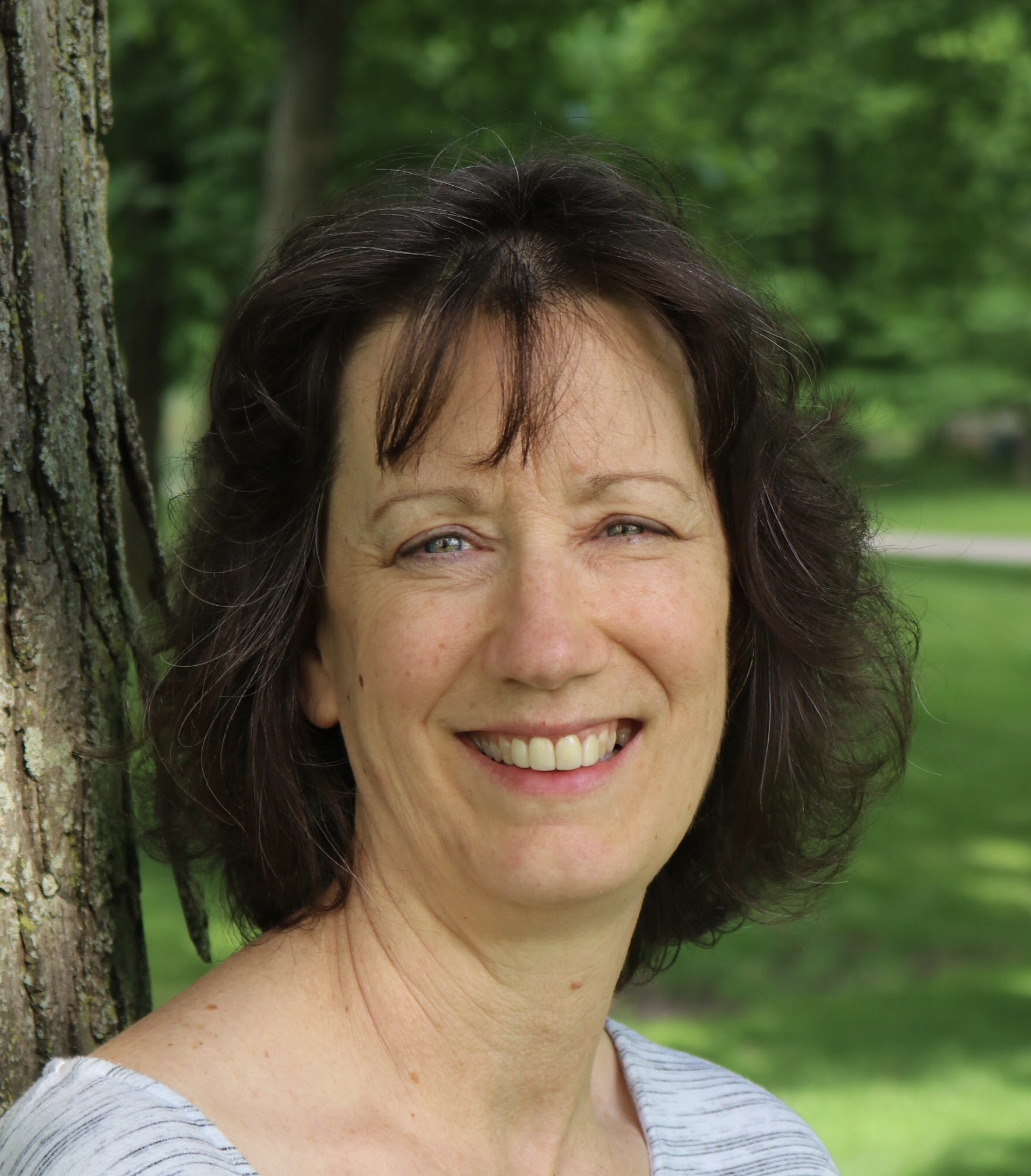 woman with brown hair under a tree