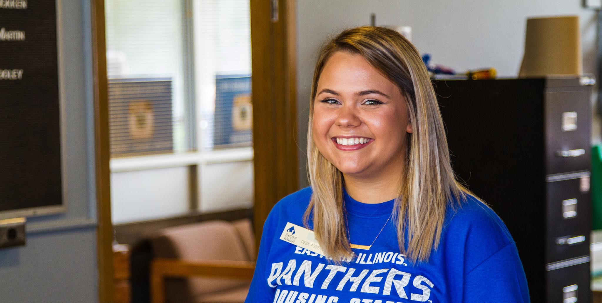Desk assistant smiling at front desk