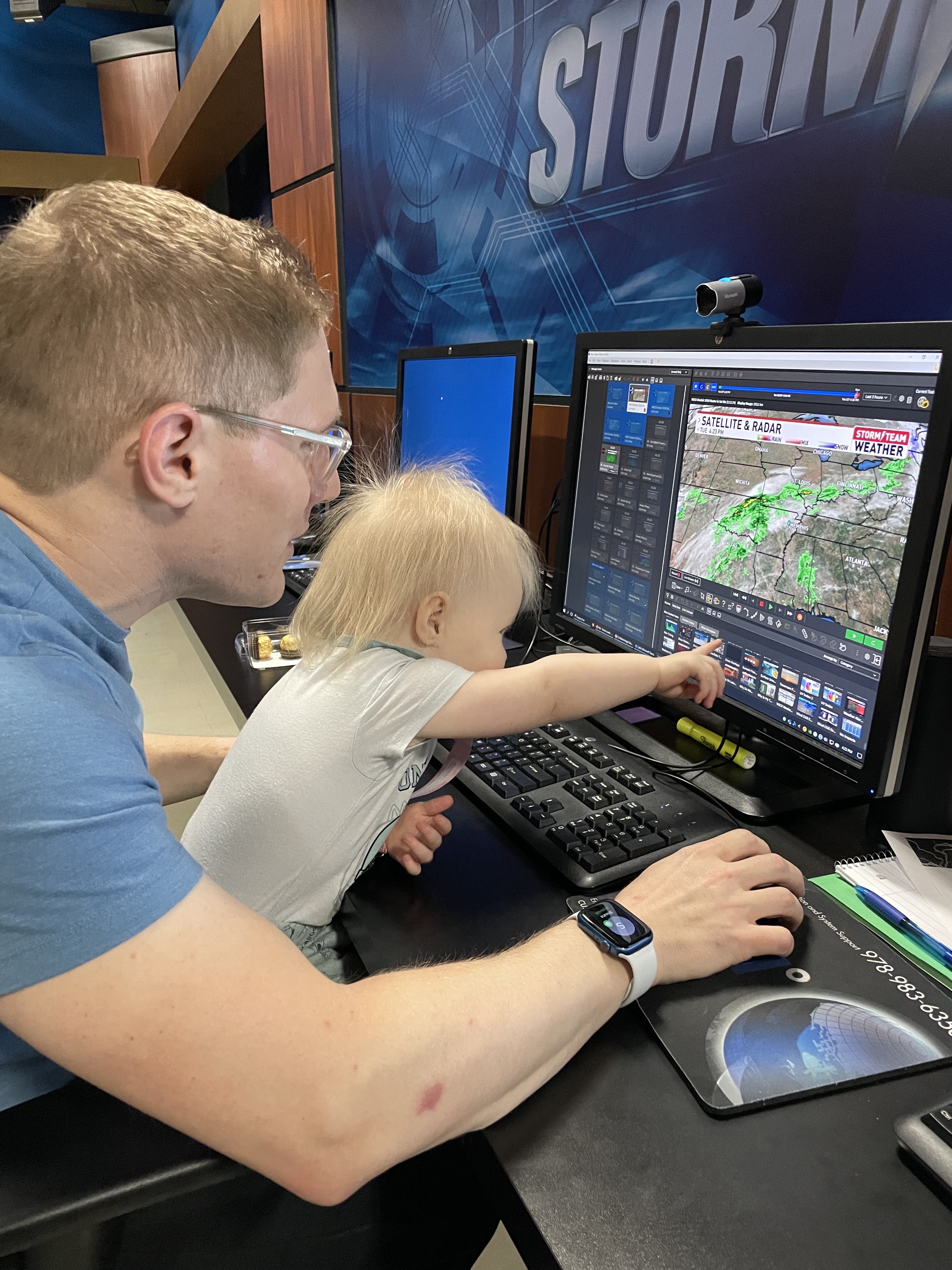 Former &ldquo;SkyWatch&rdquo; Forecaster, Darren Leeds (&rsquo;11), shows his daughter, age 2, the graphics for his show at WCCU in Champaign, Illinois. Photo used with Permission.
