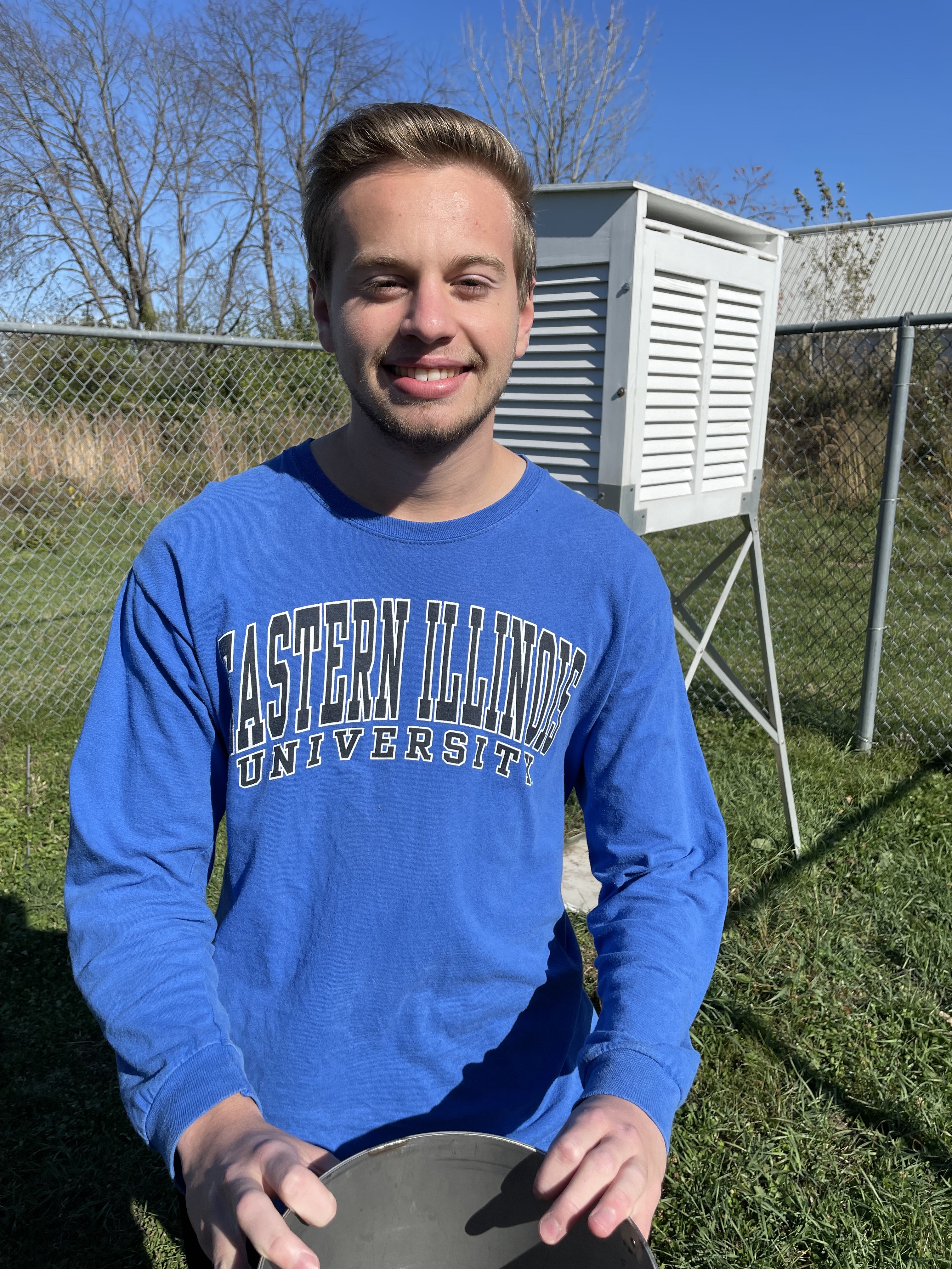 Ryan Lay ('24) stands at the EIU-NWS Weather Observation Station Station