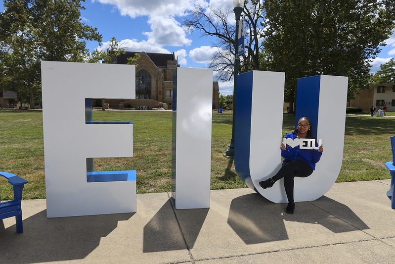 female student in front of EIU letters
