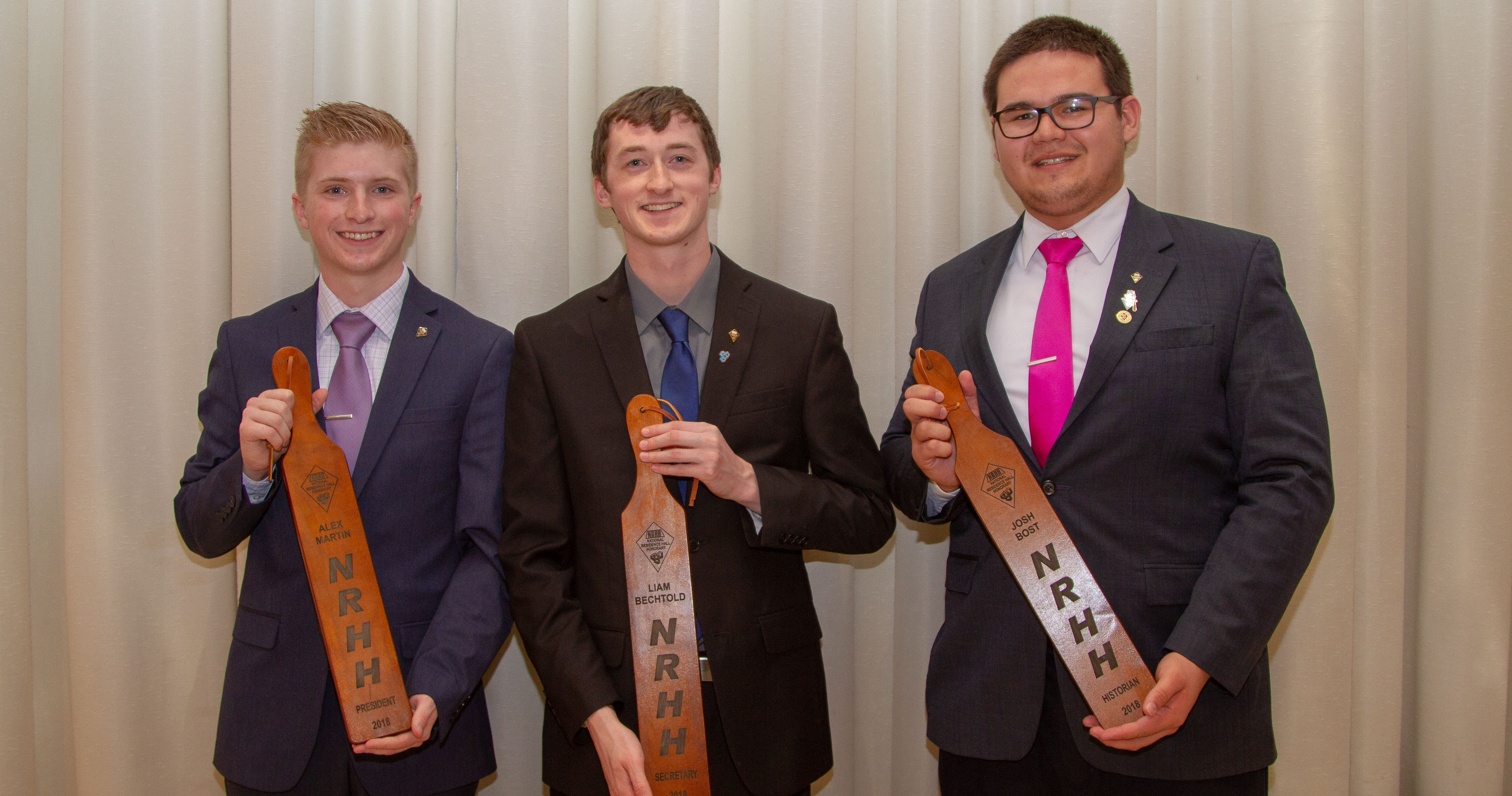 Three men holding NRHH paddles